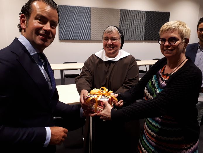 Wethouder Sidney van den Bergh neemt 350 steunbetuigingen voor de Clarissen in ontvangst van zuster Angela en SP-raadslid Marie-France van Oorsouw.