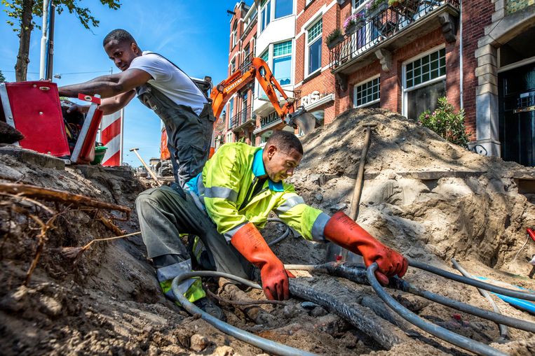 Medewerkers van Liander aan het werk aan de Middenweg in Amsterdam. Beeld Raymond Rutting