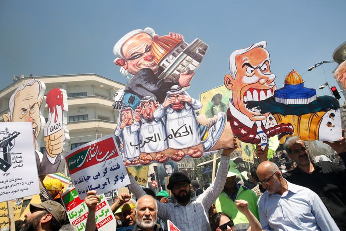 Demonstranten houden cartoon van de Israëlische premier Benjamin Netanyahu in de lucht.