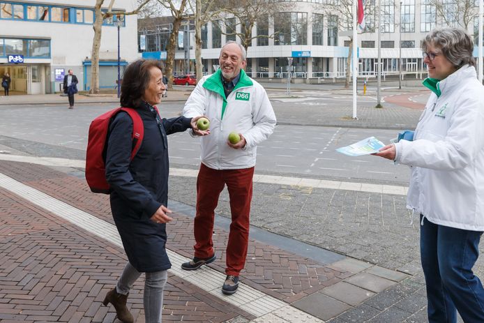 D66 reikt reizigers een appeltje voor de dorst aan bij de ingang van het NS-station in Zwolle.