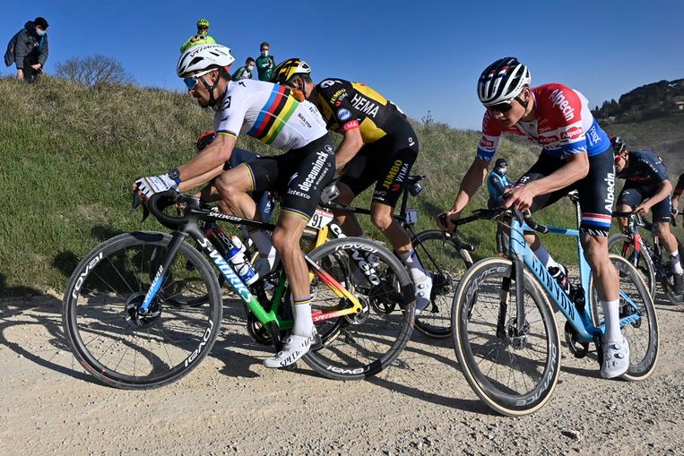 2021. Wereldkampioen Julian Alaphilippe, de Belg Wout van Aert (geel-zwart) en Mathieu van der Poel (Nederlandse kampioenstrui) over de onverharde wegen van Toscane. Voor je het weet heb je een lekke band of ga je onderuit.  Beeld BELGA