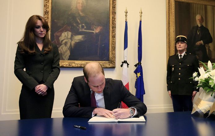 Prins William, de Hertog van Cambridge,  ondertekent een document op de typisch linkshandige manier.