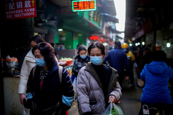 Des personnes portant des masques de protection marchent sur un marché de rue, suite à une épidémie de coronavirus (COVID-19) à Wuhan, province de Hubei, Chine, le 8 février 2021.