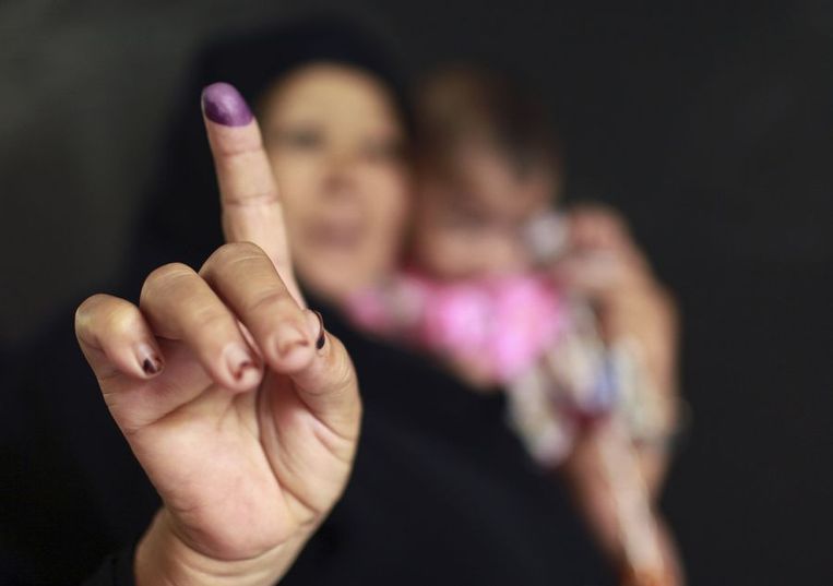 Een vrouw toont de inkt op haar vinger, bewijs dat ze gestemd heeft. Beeld reuters