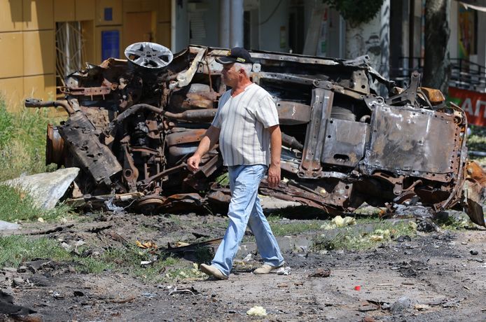 Een inwoner loopt door de verwoeste straten van Lysytsjansk.