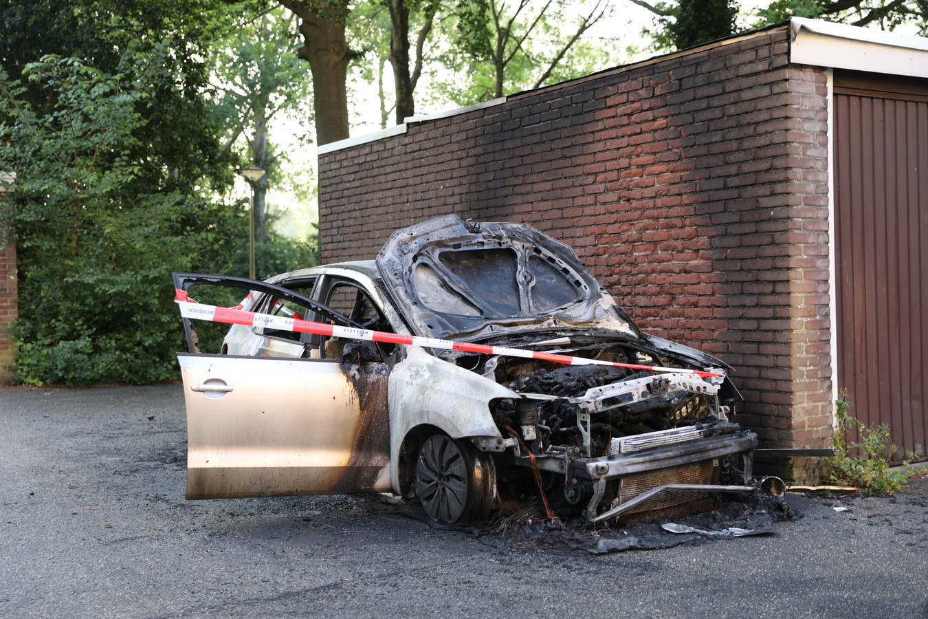 Auto brandt uit bij flat in Ede, brandweer voorkomt dat garageboxen vlam vatten Foto