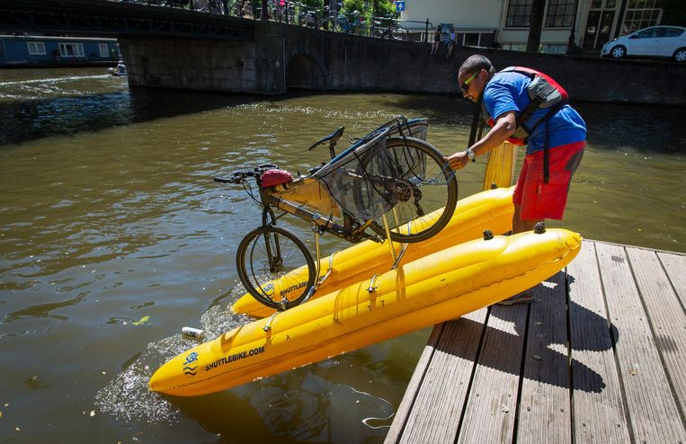 Dhruv Boruah laat zijn waterfiets in de gracht glijden. De milieuactivist uit Londen vist plastic uit het water. Beeld Dingena Mol