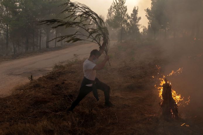 Wanhopige inwoners van de buitenwijken van Athene proberen op alle mogelijke manieren het vuur tegen te houden.