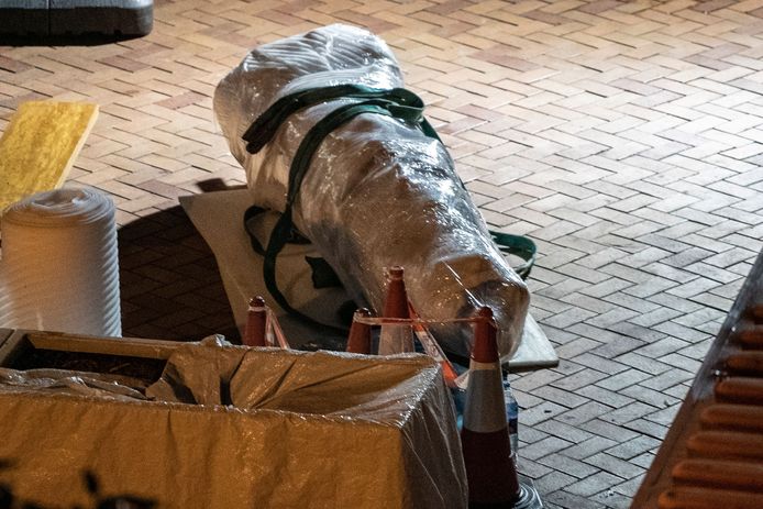 Een sectie van het ontmantelde monument ligt ingepakt klaar om in een container geplaatst te worden.