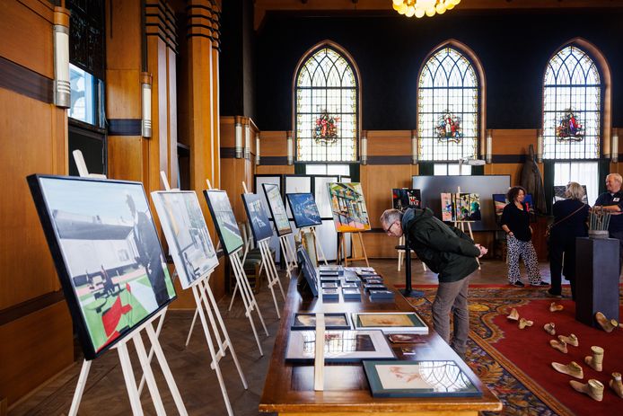 Op de achtergrond Madelon de Graauw, mede-organisator van Pop Up Raadhuis, met haar schilderijen.
