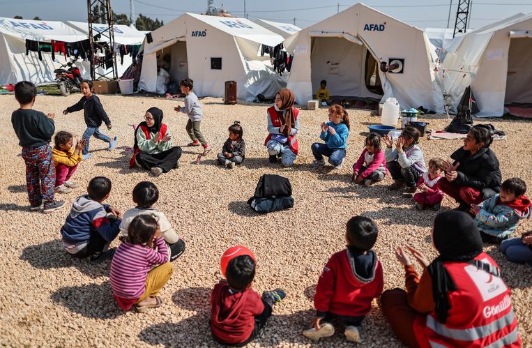 Werknemers van de Turkse Rode Halve Maan spelen met kinderen in een tentenkamp in Hatay, Turkije. Beeld ANP / EPA