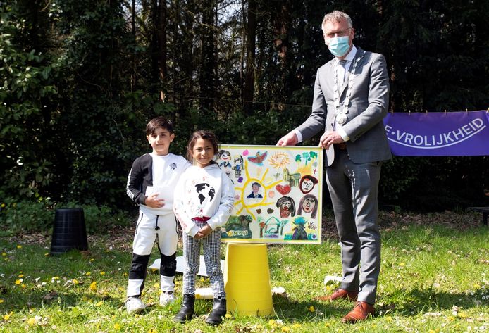 Burgemeester Hans Janssen van Oisterwijk neemt tekeningen van kinderen van het azc in ontvangst.