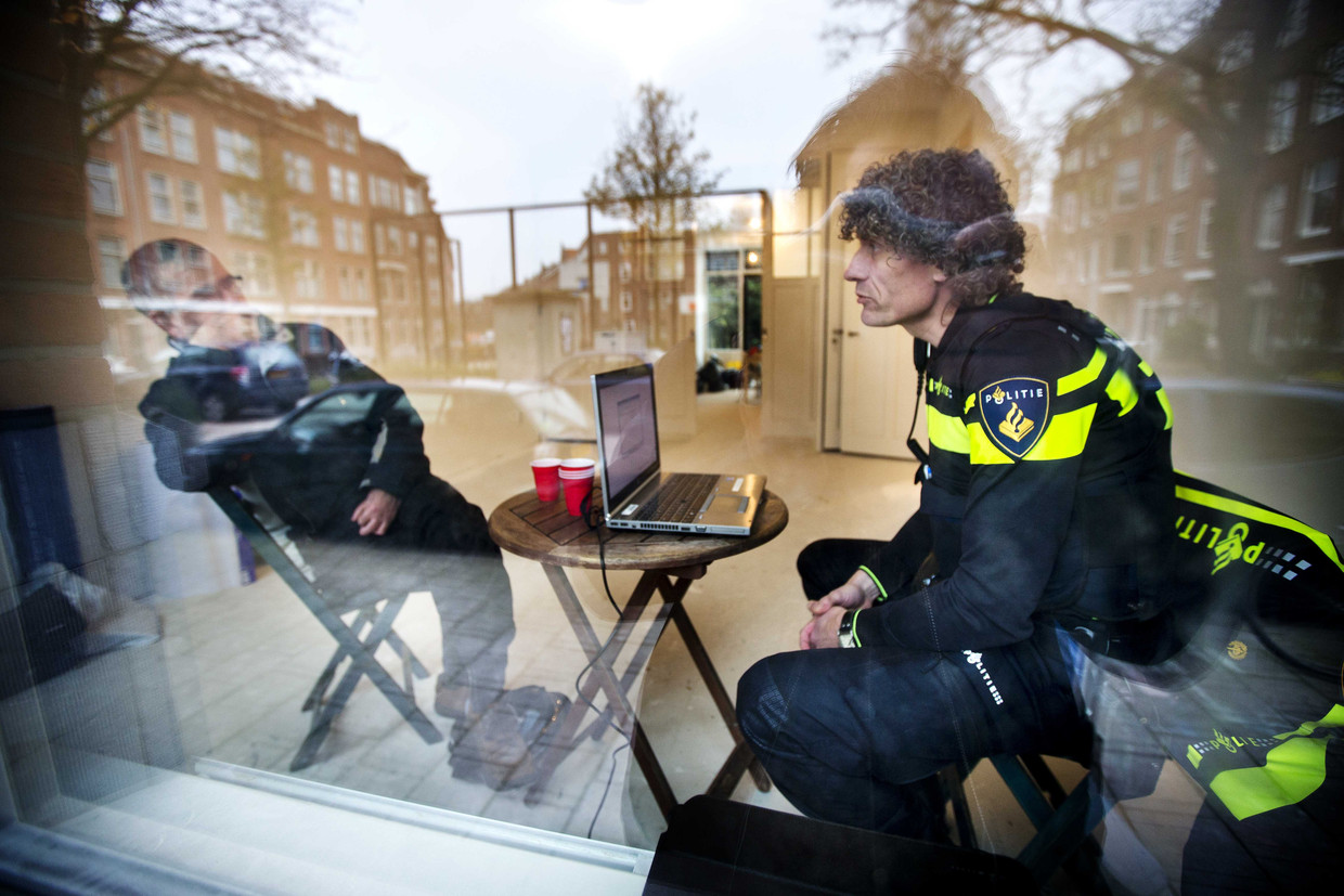 Wijkagent Wilco Berenschot praat met een buurtbewoner in zijn pop-up politiebureau in Rotterdam West, waar buurtbewoners binnenstappen voor een koffie, een praatje, een klacht of een probleem.  Beeld ANP