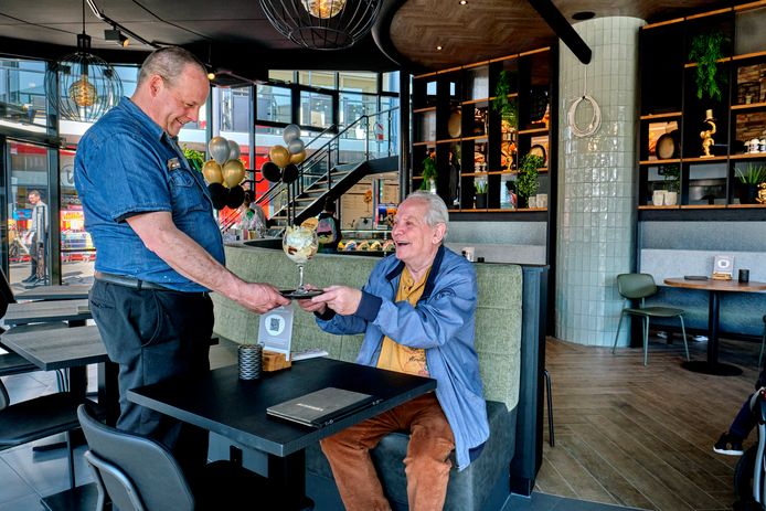 Walter Weeda serveert een ijsje aan een klant in het vernieuwde restaurant van Verhage.