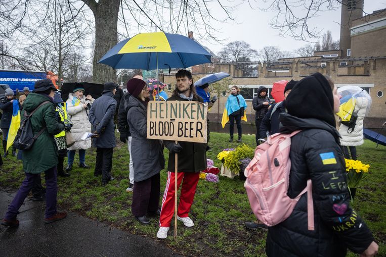 Protestbord tegen bierbrouwer Heineken tijdens een herdenkings- en solidariteitstocht voor Oekraïne in Den Haag. Beeld Laurens van Putten/ANP 