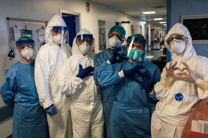 Verplegend personeel van het ziekenhuis in Cremona, nabij Milaan, vormt een hartje aan het begin van de shift.