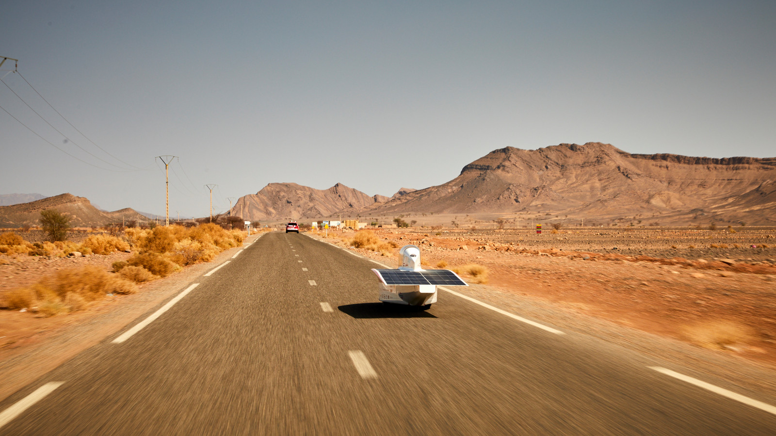 De auto van Solar Team Twente door het Sahara-landschap.