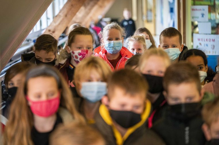 Leerlingen van een basisschool met mondkapjes in de gang. Vanwege de aangescherpte coronamaatregelen moeten leerlingen vanaf groep 6 mondkapjes dragen als ze zich bewegen. Beeld ANP