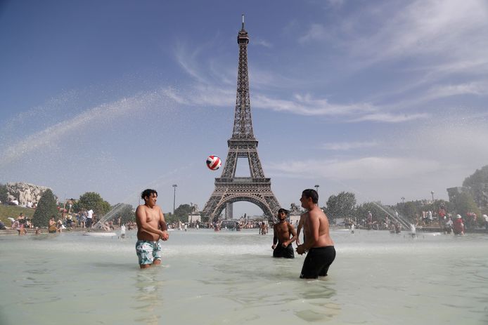 Mensen spelen en baden in de Trocadero fontein voor de Eiffeltoren tijdens een hittegolf op 28 juni.