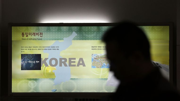 Een man passeert een kaart van het Koreaanse schiereiland bij de gedemilitariseerde zone tussen de twee Korea's. Beeld ap