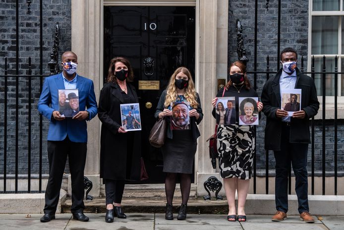 Demonstranten voor de ambtswoning van premier Boris Johnson in Londen houden foto's omhoog van familieleden die zijn overleden aan de gevolgen van Covid-19.