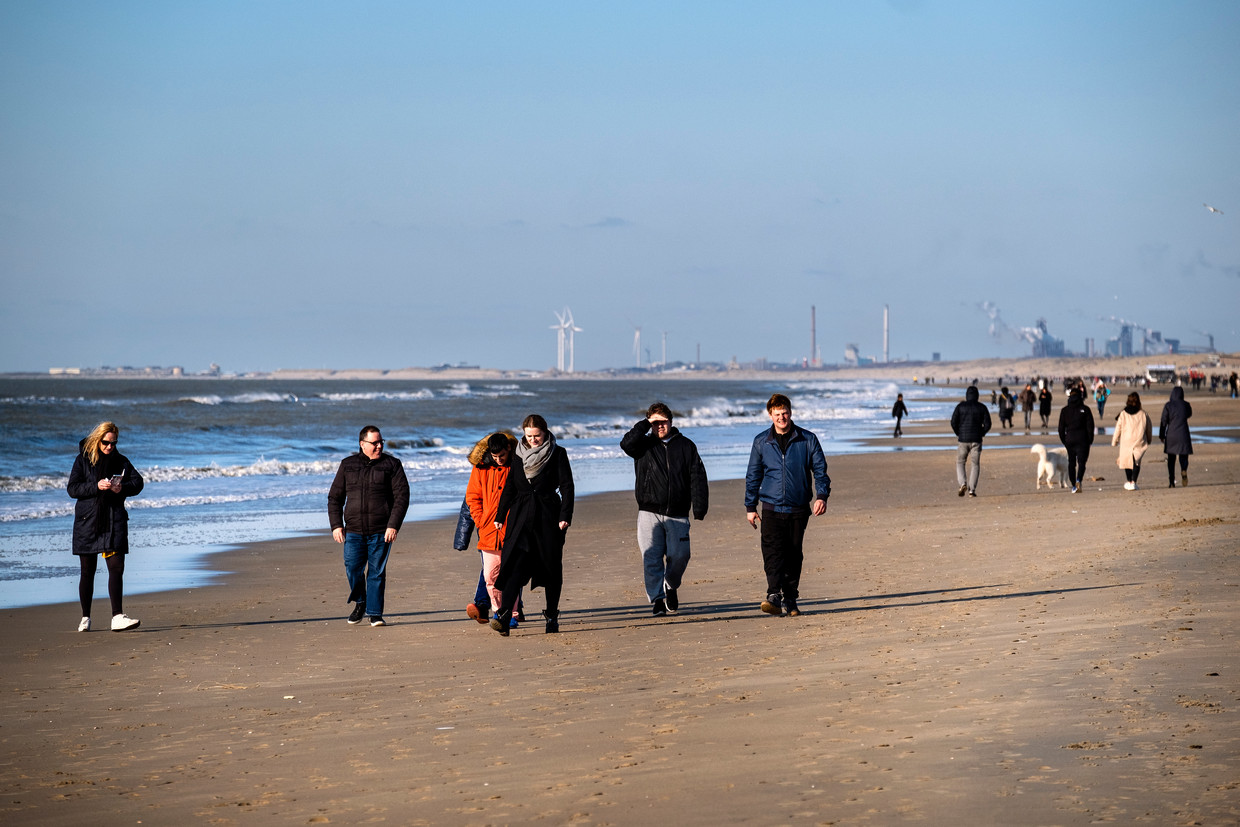 Dagjesmensen op het strand van Zandvoort tijdens de zonnige zaterdag. Op grote matrixborden wordt de strandgangers gevraagd zich te houden aan de coronamaatregelen.  Beeld ANP