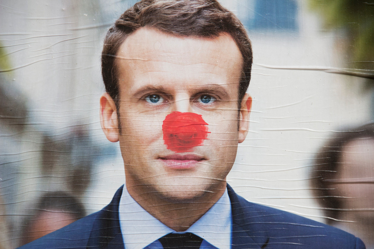 Een besmeurde campagneposter van Emmanuel Macron. De huidige president zou maar op 23 procent staan in de laatste peilingen, het zou dus een spannende verkiezing kunnen worden. Beeld Martin Bertrand