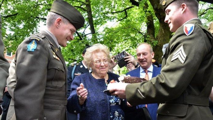 Amerikaanse soldaten geven een verjaardagstaart aan Meri Merion voor haar negentigste verjaardag.