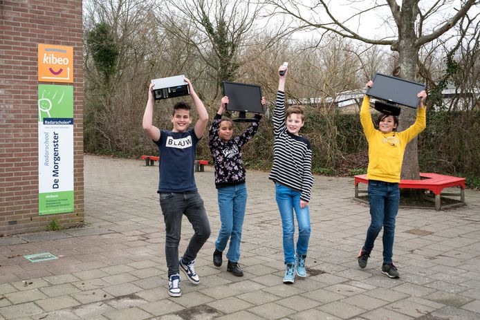 Vlnr: Joost Timmers, Victoria van Emden, Arjan van de Panne en Antonio Gutierrez op het schoolplein van De Morgenster met wat oude apparaten die alweer ingezameld zijn voor volgend jaar
