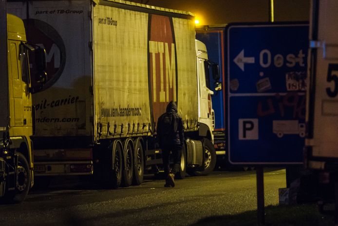 Een transmigrant zoekt op een Belgische snelwegparking naar een vrachtwagen om in te kruipen. (Archieffoto)
