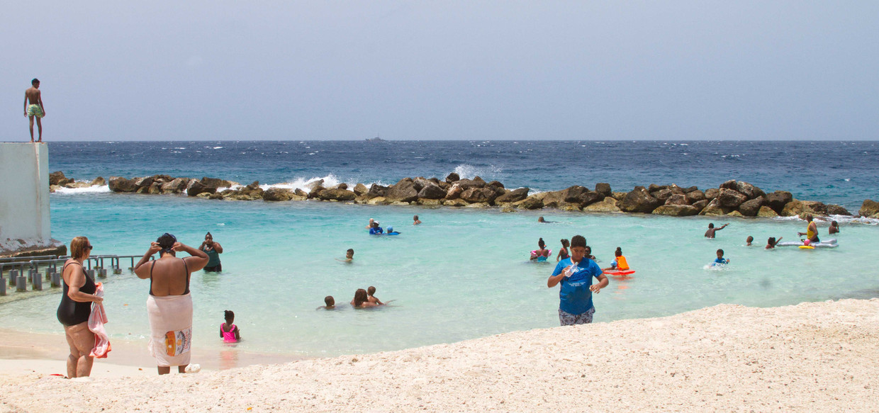 Badgasten op het strand van Willemstad, half mei. De stranden waren enkele weken nagenoeg verlaten, maar het openbare leven op Curaçao komt weer op gang nadat de lockdown werd versoepeld. Beeld ANP