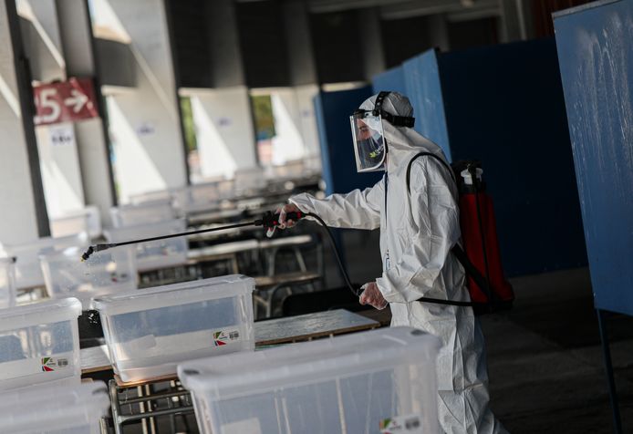 Een arbeider desinfecteert een stembureau in hoofdstad Santiago.