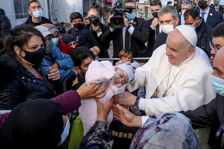 Paus Franciscus ontmoet enkele vluchtelingen in het kamp en geeft zijn zegen aan één van de baby's.  Beeld EPA