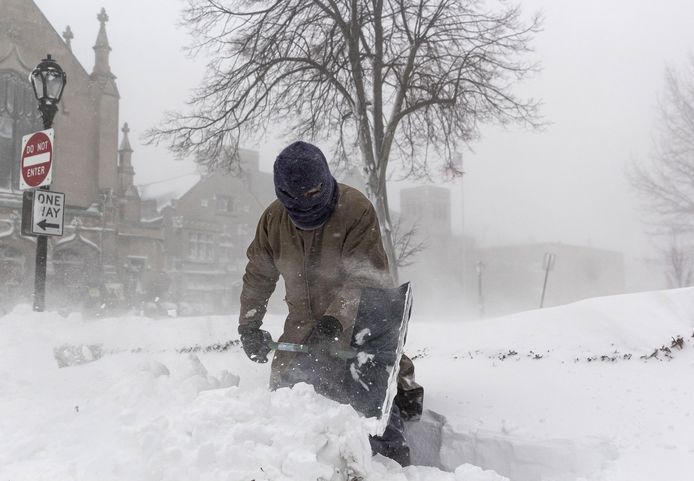 Мужчина пытается убрать снег с тротуара в Буффало, штат Нью-Йорк.