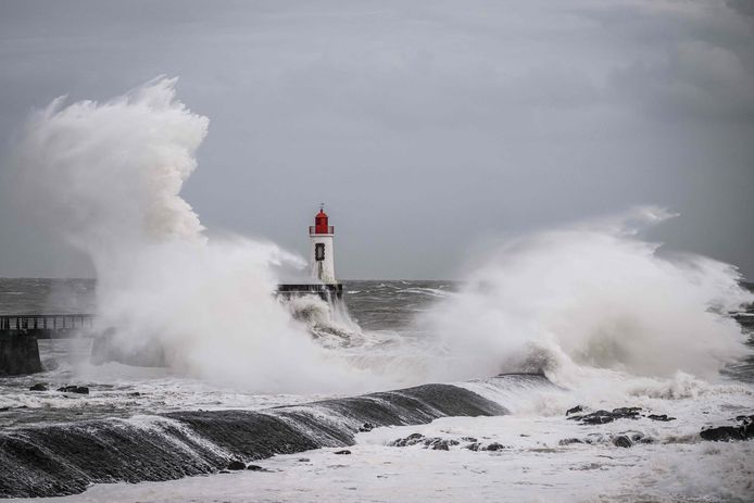 Hoge golven beuken tegen een vuurtoren door storm Nelson in Les Sables-d'Olonne, in het westen van Frankrijk.