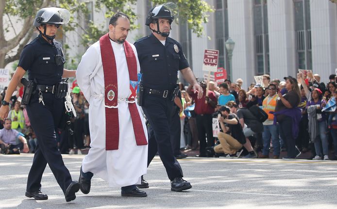 Een priester wordt gearresteerd tijdens een demonstratie tegen het bezoek van de Amerikaanse Justitieminister Jeff Sessions in Los Angeles waarbij de demonstranten een straat afsloten.