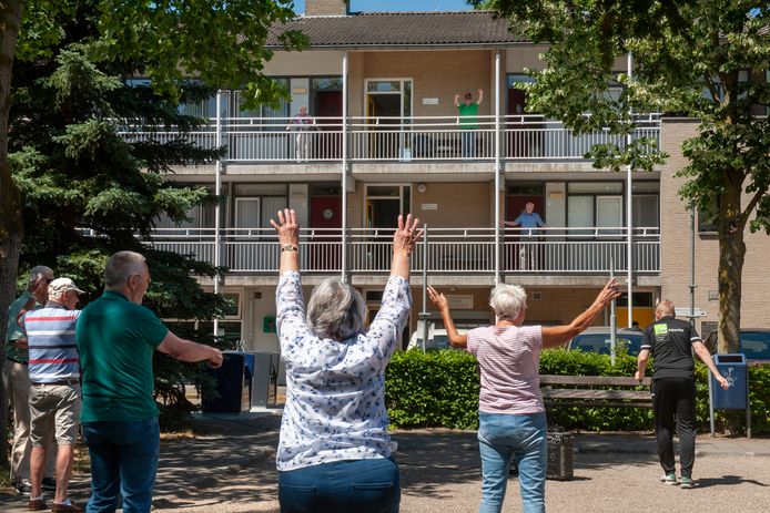 De senioren van jeu-de-boules club 'De Actieven' bewegen mee met de ouderen op de galerij van het appartementencomplex in Rosmalen