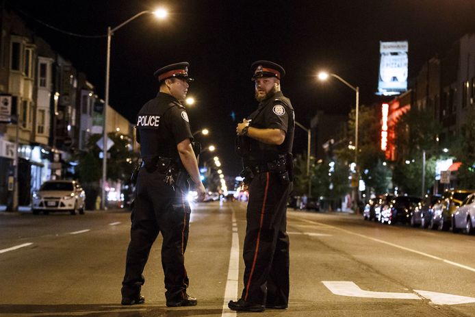 Politiemannen in Danforth Street in Toronto waar de schietpartij plaatsvond.