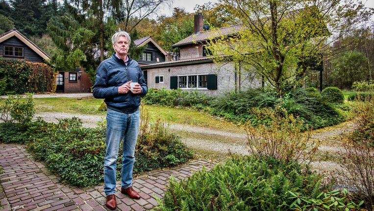 Gert Griffioen bij zijn huis (rechts). Linksachter staat het huis van de buurman. Beeld Raymond Rutting / de Volkskrant