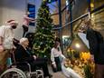 Studenten versieren een kerstboom bij verzorgingstehuis de Taling.