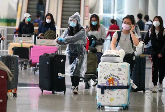 Archiefbeeld 18 maart 2020: reizigers komen aan in de internationale luchthaven van Hongkong. 