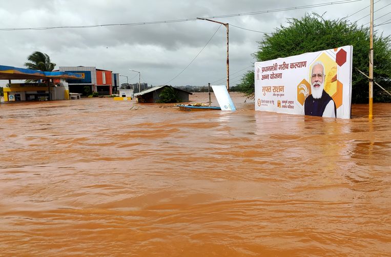Een billboard met premier Narenda Modi staat onder water in Kolhapur in de regio Maharashtra. Duizend mensen werden al gered bij de overstromingen.  Beeld AP