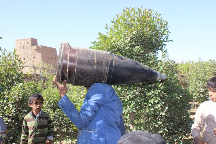 Een man draagt een onderdeel van een raket die tijdens een Saoedische luchtaanval op de stad Saada werd gedropt.