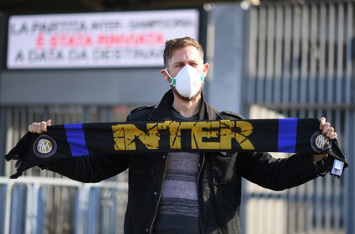 Een Inter-fan draagt een mondkapje voor het coronavirus.