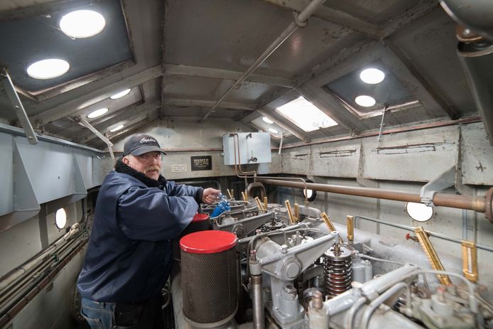 De eigenaar van de sleepboot Laura controleert de temperatuur van de motor en hanteert de oliespuit.