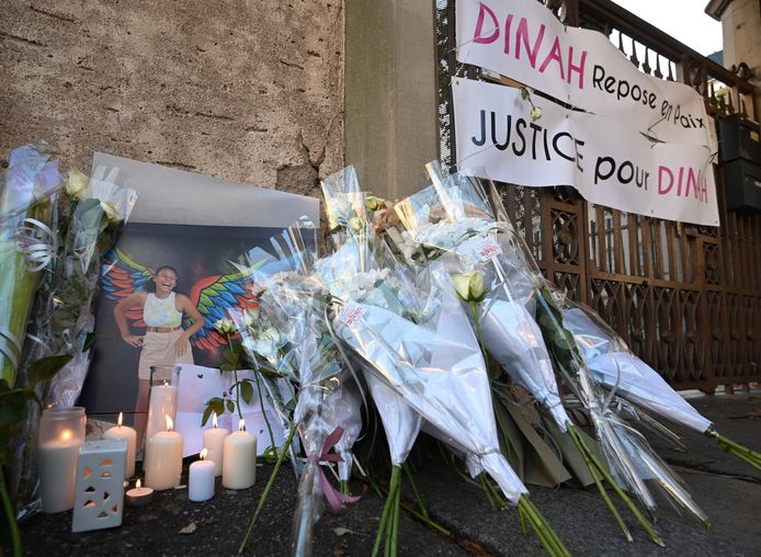 Des bouquets de fleurs sont exposés devant l'entrée du collège Jean-Henri Lambert, à côté de banderoles sur lesquelles on peut lire "Dinah repose en paix", "Justice pour Dinah", lors d'une marche blanche à Mulhouse, dans l'est de la France, le 24 octobre 2021.