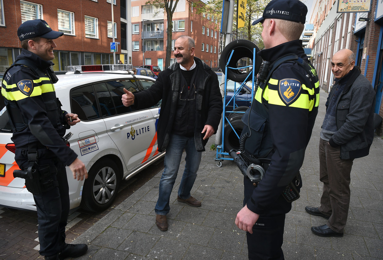 Wijkagenten in het Oude Westen in Rotterdam hebben plezier met een Turkse ondernemer. Beeld Marcel van den Bergh / de Volkskrant