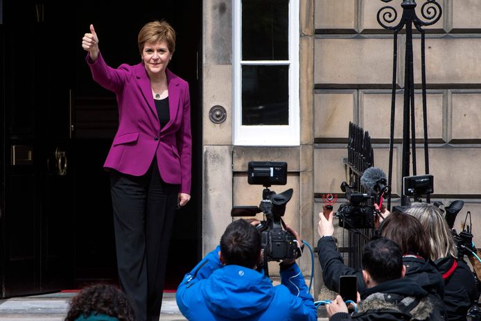 De Schotse premier en partijleider van de SNP, de Schotse nationalisten, zwaait naar de pers vanaf de drempel van Bute House in Edinburgh haar officiële residentie.