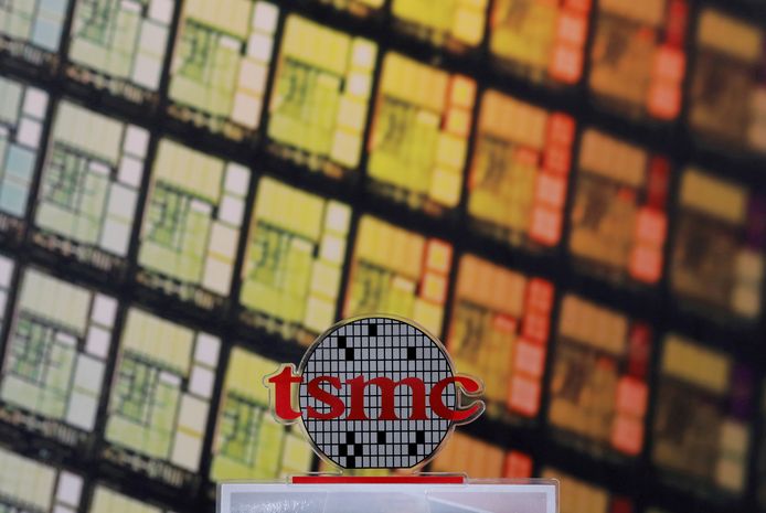 Het logo van TSMC met op de achtergrond computerchips.