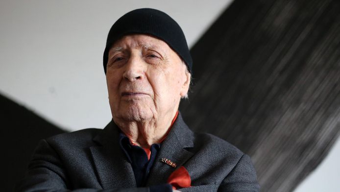 Karl Otto Goetz poseert voor een van zijn schilderijen.